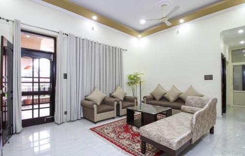 a living room with a couch and a table at Touristen Holiday Home A luxury Villa in Dharamshala
