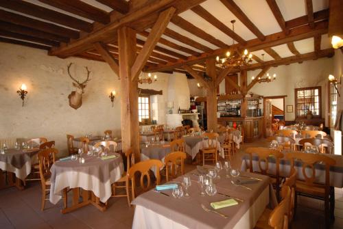 um restaurante com mesas e cadeiras num quarto em Logis Hôtels Restaurant Le Relais Chenonceaux em Chenonceaux