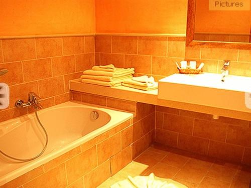 a bathroom with a tub and a sink and towels at Sahara Douz in Douz