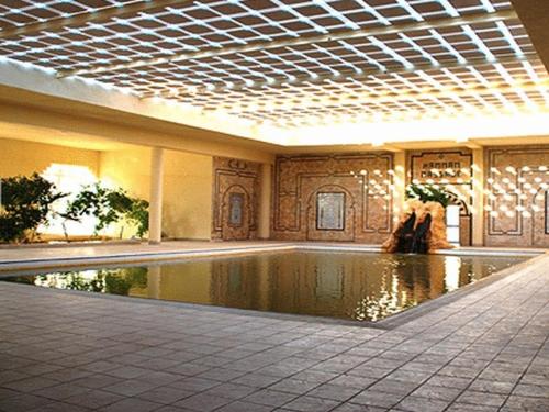a swimming pool in a large building with a ceiling at Sahara Douz in Douz