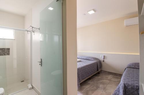 a bathroom with a shower and a bed at Pousada Espindola in Penha