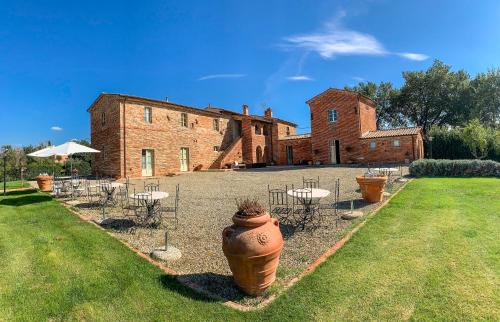 un gran edificio con un patio con mesas y sillas en Casale Cardini, en Foiano della Chiana