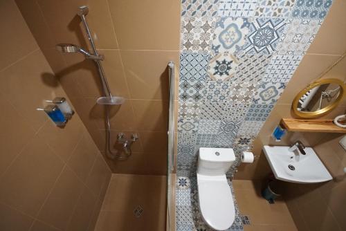 a bathroom with a toilet and a sink at Hotel Cordata in Tbilisi City