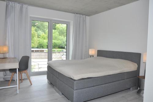 una camera con letto, scrivania e finestra di Duenengras a Heikendorf