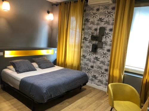 
a bedroom with a bed and a dresser at boutique Hôtel Azur in Marseille
