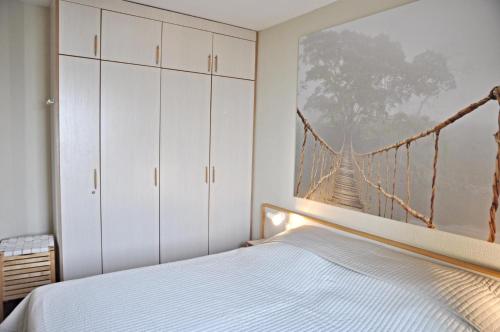 Schlafzimmer mit einem Bett mit einem Gemälde einer Hängebrücke in der Unterkunft Strandhotel 5 in Laboe