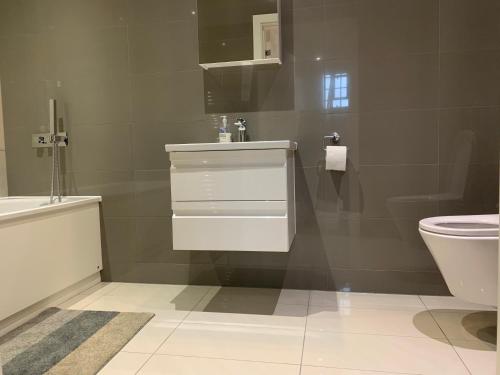 a bathroom with a white sink and a toilet at London City Hotel in Woolwich