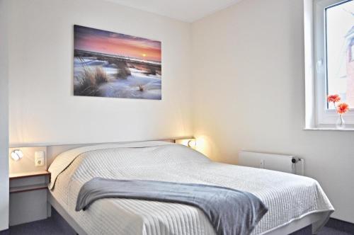 um quarto com uma cama e uma fotografia na parede em Panorama 1 em Laboe