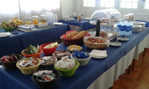 un lungo tavolo blu con cesti di cibo sopra di Apartamentos Sa Cala a Cala Morell