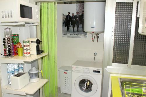 eine Küche mit einer Waschmaschine und einem grünen Vorhang in der Unterkunft Cosmo Grey in Hospitalet de Llobregat