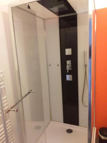 une douche avec une porte vitrée dans une salle de bain dans l'établissement Cocooning gaillard, à Brive-la-Gaillarde