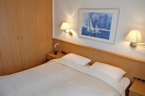 um quarto com uma cama e uma fotografia de um veleiro na parede em Nautic 12 em Laboe