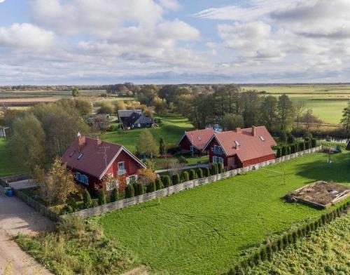 an aerial view of a house in a field with a fence at Sodyba Senoji Rusnė in Rusnė
