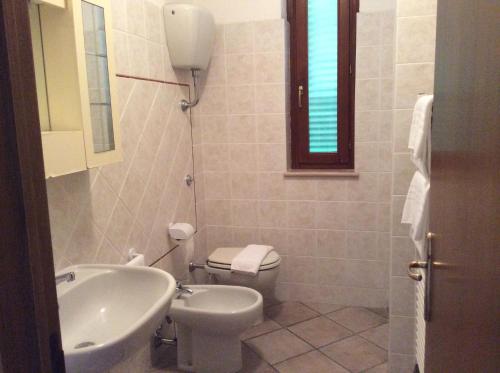 a bathroom with a sink and a toilet and a window at Casale Fonterosa in Montemerano