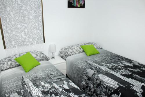 twee bedden naast elkaar in een slaapkamer bij Cosmo Grey in Hospitalet de Llobregat