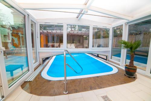 an indoor swimming pool in a house with glass walls at Hotel am Gutspark Prager GbR in Leipzig