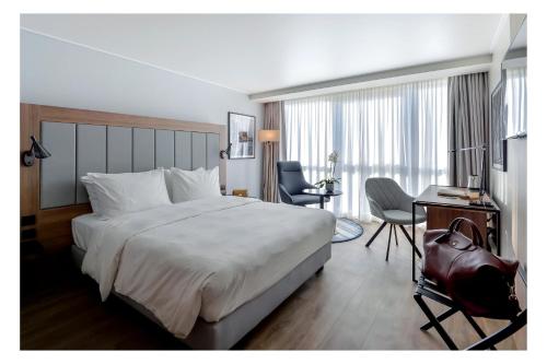 a hotel room with a large bed and a desk at Radisson Blu Hotel Nice in Nice