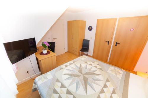 a small room with a bed and a television at Hotel am Gutspark Prager GbR in Leipzig