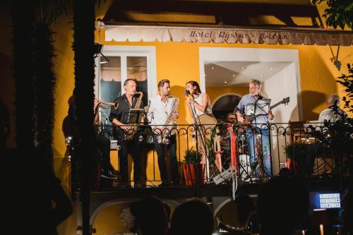 un groupe d'hommes debout sur un balcon dans l'établissement Art Hotel Riposo, à Ascona