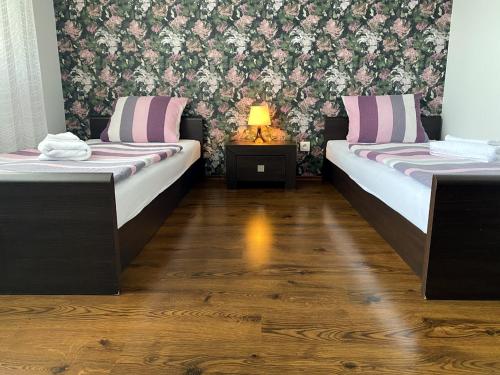una camera con due letti e un tavolo con una lampada di Gloria a Olomouc
