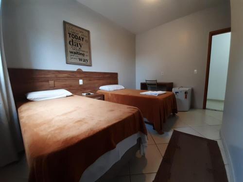 a hotel room with two beds and a sign on the wall at Hotel Casablanca Suites in Indaiatuba