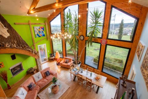 einen Blick über ein Wohnzimmer mit großen Fenstern in der Unterkunft Au Domaine du Cerf in Vyans