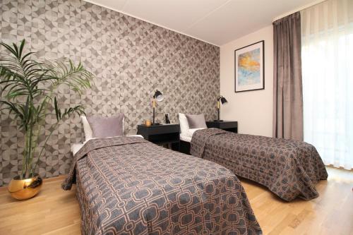 une chambre d'hôtel avec deux lits et une usine dans l'établissement Tallinn City Apartments Roosikrantsi, à Tallinn
