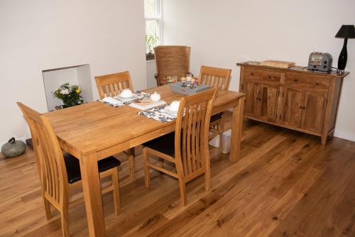 a wooden dining room table and chairs in a room at Albatross B&B Dornoch in Dornoch