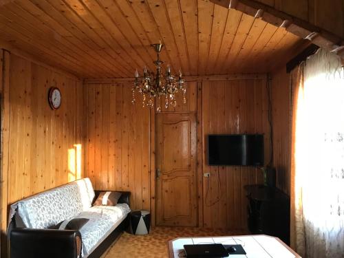 a living room with a couch and a chandelier at Дом для отдыха близко Батуми in Batumi