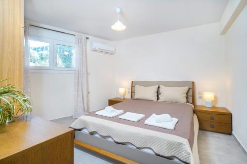 a bedroom with a bed with two towels on it at SYKA Thassos - Apartment down floor SKALA RACHONIOU in Skala Rachoniou