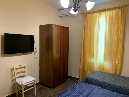 1 dormitorio con 1 cama, armario y TV en beb elia, en Nápoles