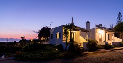 a white house with a sunset in the background at Margarita Apartments in Ierápetra