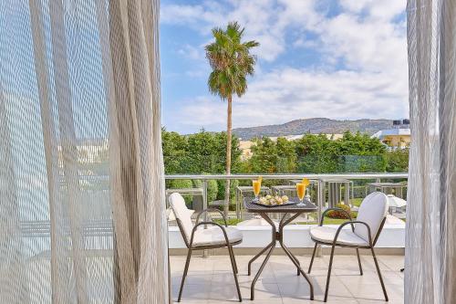 einen Balkon mit einem Tisch, Stühlen und einer Palme in der Unterkunft Castello Boutique Resort & Spa - Adults Only in Sisi
