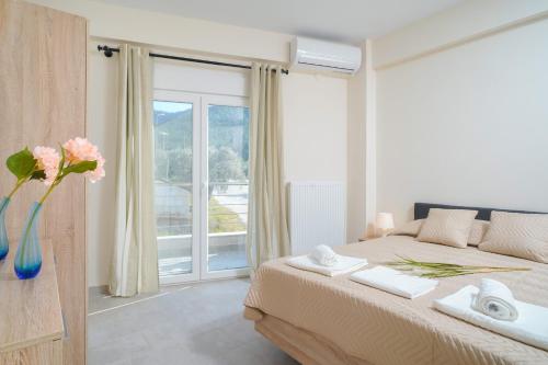 una camera con un letto e una grande finestra di Skala Rachoni Cris Luxury Apartment Upper Floor a Skala Rachoniou