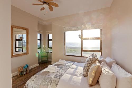 a bedroom with a bed and a large window at Beachfront Apartment @ Morleenpark unit 11 in Swakopmund