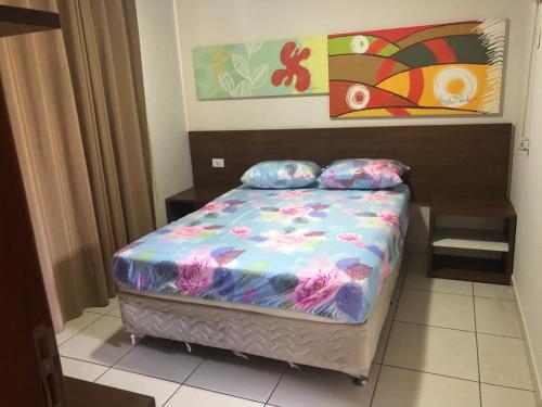 a small bed in a room with a painting at Apartamento Caldas Novas in Caldas Novas