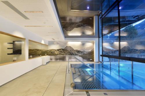 a swimming pool in a building with paintings on the walls at Venediger Lodge in Neukirchen am Großvenediger