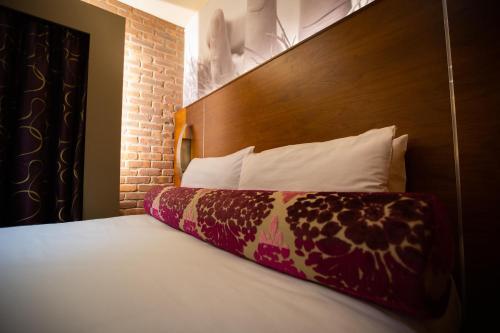a bedroom with a bed with a wooden head board at The Crown Hotel Bawtry-Doncaster in Doncaster