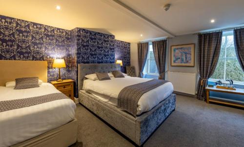 A bed or beds in a room at Alston House Hotel