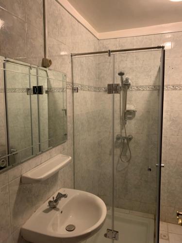y baño con lavabo y ducha acristalada. en Gueliz Imane Centre Américain, en Marrakech