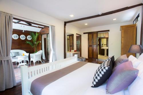 a bedroom with a large white bed and a balcony at Tolani Northgate Villa Chiang Mai in Chiang Mai