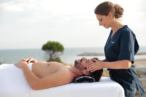 a woman is giving a man a massage at Hôtel Les Corallines - Thalasso & Resort in La Grande-Motte