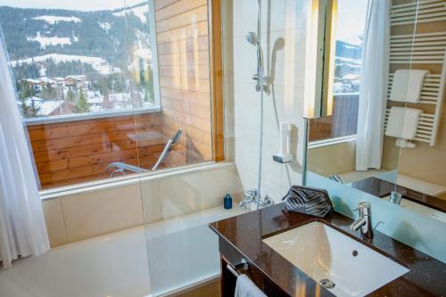 a bathroom with a tub and a sink and a shower at TUI BLUE Fieberbrunn in Fieberbrunn