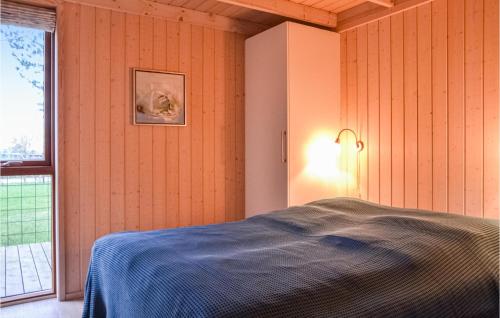 a bedroom with a bed and a lamp and a window at Stunning Home In Grsted With Wifi in Græsted