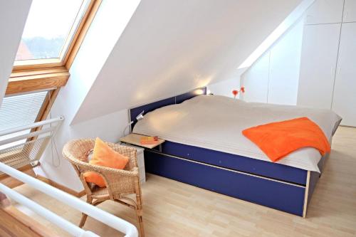 ein kleines Schlafzimmer mit einem Bett und einem Stuhl in der Unterkunft Windjammer: Passat in Laboe