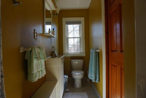 a bathroom with a toilet and a sink and a window at The Royal Oak in Cranston