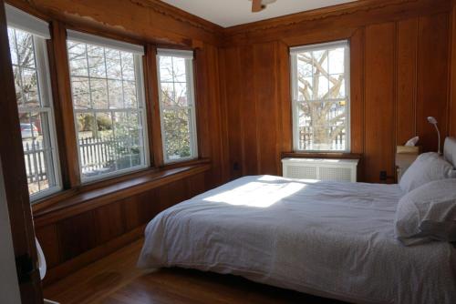 a bedroom with wooden walls and a bed with windows at The Royal Oak in Cranston