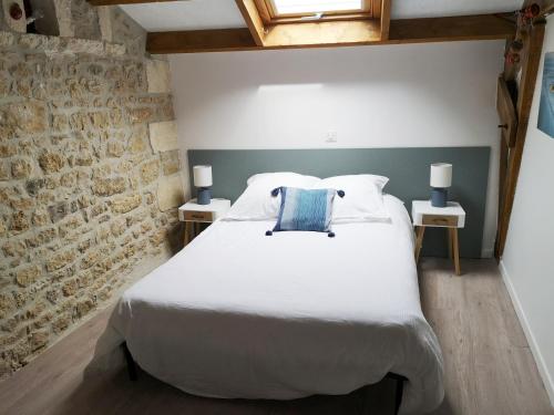 una camera da letto con un grande letto bianco con due lampade di au pied de l'Ile Oléron a Bourcefranc