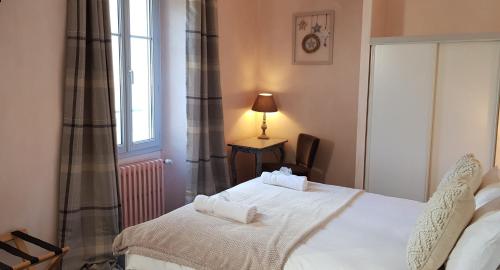 a bedroom with a white bed and a window at Hôtel Terminus in Luz-Saint-Sauveur