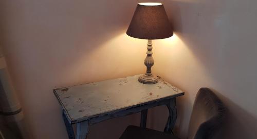 a table with a lamp sitting on top of it at Hôtel Terminus in Luz-Saint-Sauveur